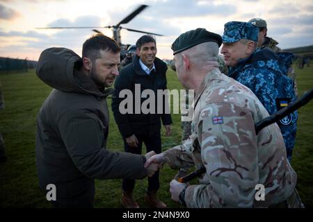 Lulworth, Vereinigtes Königreich. 08. Februar 2023. Der britische Premierminister Rishi Sunak, rechts, und der ukrainische Präsident Volodymyr Zelenskyy, links, werden bei der Ankunft im Bovington Camp Armour Centre am 8. Februar 2023 in Lulworth, Dorset, Großbritannien, von ukrainischen und britischen Offizieren begrüßt. Sunak und Zelenskyy besuchten ukrainische Soldaten, die von der britischen Armee auf Challenger-2-Panzern ausgebildet wurden. Kredit: Pool Photo/Pressestelle Des Ukrainischen Präsidenten/Alamy Live News Stockfoto