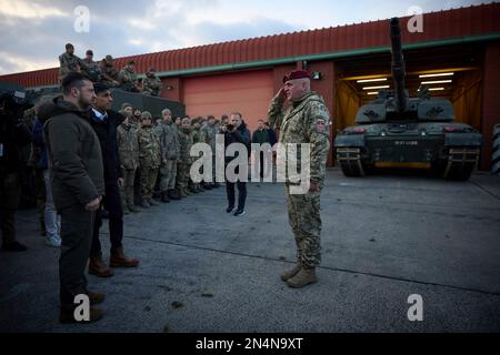 Lulworth, Vereinigtes Königreich. 08. Februar 2023. Der britische Premierminister Rishi Sunak, rechts, und der ukrainische Präsident Volodymyr Zelenskyy, links, werden vom ukrainischen Offizier begrüßt, der am 8. Februar 2023 im Bovington Camp Armour Centre in Lulworth, Dorset, Großbritannien, ausgebildet wurde. Sunak und Zelenskyy besuchten ukrainische Soldaten, die von der britischen Armee auf Challenger-2-Panzern ausgebildet wurden. Kredit: Pool Photo/Pressestelle Des Ukrainischen Präsidenten/Alamy Live News Stockfoto