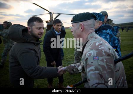 Lulworth, Vereinigtes Königreich. 08. Februar 2023. Der britische Premierminister Rishi Sunak, rechts, und der ukrainische Präsident Volodymyr Zelenskyy, links, werden bei der Ankunft im Bovington Camp Armour Centre am 8. Februar 2023 in Lulworth, Dorset, Großbritannien, von ukrainischen und britischen Offizieren begrüßt. Sunak und Zelenskyy besuchten ukrainische Soldaten, die von der britischen Armee auf Challenger-2-Panzern ausgebildet wurden. Kredit: Pool Photo/Pressestelle Des Ukrainischen Präsidenten/Alamy Live News Stockfoto