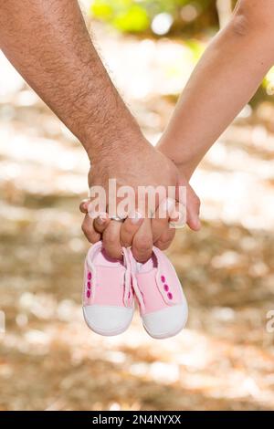 Eltern, Die Hände Halten, Mit Schuhen Für Das Ungeborene Baby. Stockfoto