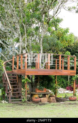 Balkon romantisch, braunes Holz um einen Baum herum. Stockfoto