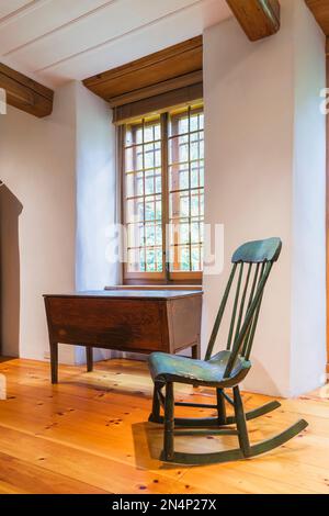 Antiker grüner hölzerner Boston Schaukelstuhl aus den 1880er Jahren im Wohnzimmer in einem alten Haus um 1750. Stockfoto