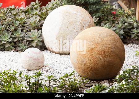 Runde Steine in verschiedenen Größen und Farben schmücken den Garten. Stockfoto