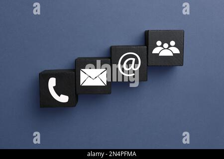 Hotline-Service. Schwarze Würfel mit Symbolen auf dunklem Hintergrund, flach liegend Stockfoto