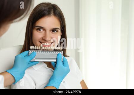 Arztprüfung der Zahnfarbe junger Frauen in der Klinik. Kosmetische Zahnheilkunde Stockfoto