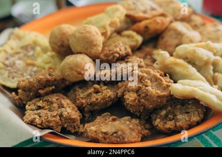 Lokale Snacks aus Ponorogo, Indonesien genannt Lentho aus tolo-Bohnen, serviert mit einem anderen Gorengan, umfassen Pisang Goreng, Tofu und Tempeh Goreng. Stockfoto