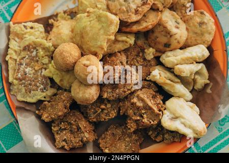 Lokale Snacks aus Ponorogo, Indonesien genannt Lentho aus tolo-Bohnen, serviert mit einem anderen Gorengan, umfassen Pisang Goreng, Tofu und Tempeh Goreng. Stockfoto