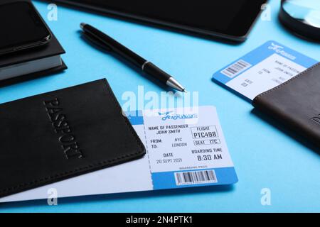 Pässe mit avia-Tickets auf hellblauem Hintergrund, Nahaufnahme. Reisebüro-Konzept Stockfoto