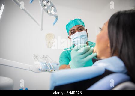 Ein afrikanischer Zahnarzt besucht einen Patienten in seiner Zahnarztpraxis, Gesundheitsversorgung in afrika Stockfoto