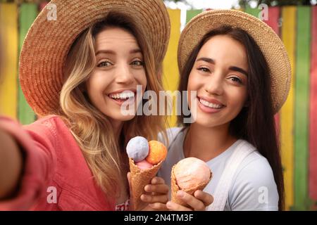 Junge Frauen mit Eiscreme machen Selfie im Freien Stockfoto