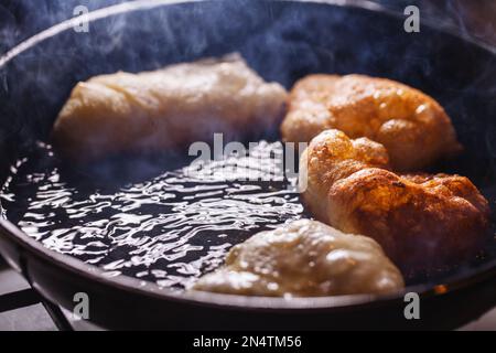 Zubereitung und gebratene Pasta in gesalzenem, kochendem Öl, typische italienische Frittiergerichte Stockfoto