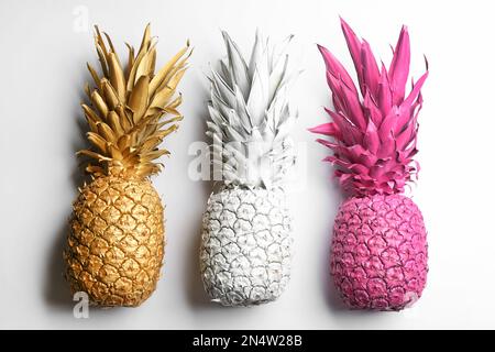 Bemalte Ananas auf weißem Hintergrund, Draufsicht. Kreatives Konzept Stockfoto