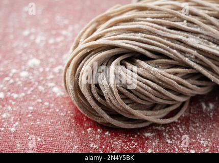 Nahaufnahme roher Soba-Nudeln. Soba vor dem Kochen. Frisch zubereitete Soba-Nudeln. Stockfoto