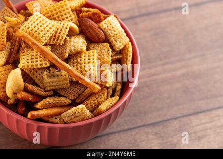 Eine Schale hausgemachter Cerealien, Nuss und Prezel Trail Mix auf einem Holztisch Stockfoto