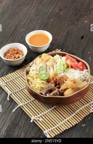 Soto Mie Bogor. Traditionelle sudanesische Rindernudelsuppe mit Frühlingsrollen, Kohl und Tomaten aus Bogor, West Java. Stockfoto