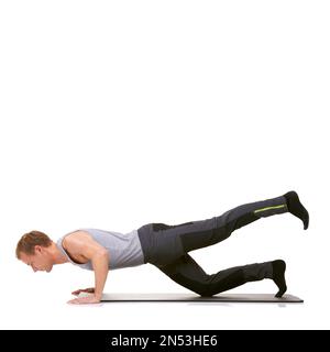 Scott macht das hier. Ein fitter junger Mann, der auf seiner Trainingsmatte trainiert, während er auf Weiß isoliert ist. Stockfoto