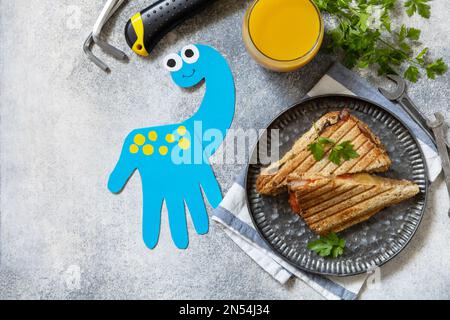 Alles gute zum Vatertag. Vatertag Karte Dinosaurier und Heimwerker Frühstück für Vater auf grauen Stein Tisch. Blick von oben. Speicherplatz kopieren. Stockfoto