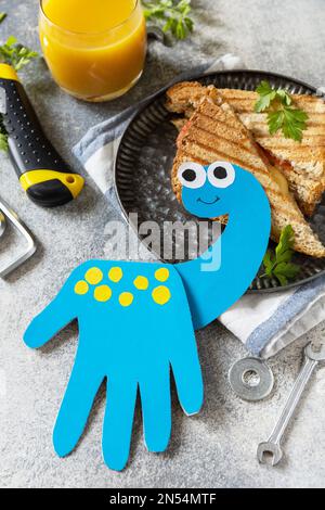 Alles gute zum Vatertag. Vatertag Karte Dinosaurier und Heimwerker Frühstück für Vater auf grauen Stein Tisch. Stockfoto