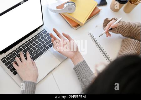 Draufsicht von zwei kreativen und professionellen asiatischen Grafikdesignerinnen, die im Büro zusammenarbeiten und über ihr Projekt diskutieren und Brainstorming durchführen Stockfoto