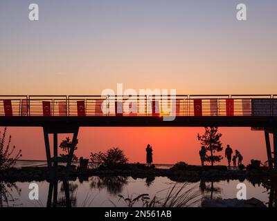 Silhouette aus Park und Menschen auf der Aussichtsplattform vor dem Sonnenuntergang. Erste Station, wo die Standseilbahn von Oludeniz nach Babadag fährt Stockfoto