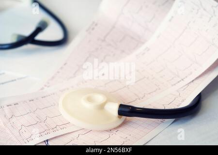 Kardiogramm mit Stethoskop auf dem Tisch, Nahaufnahme. Das Konzept der Herzkrankheiten und Herzinfarktprophylaxe. Stockfoto