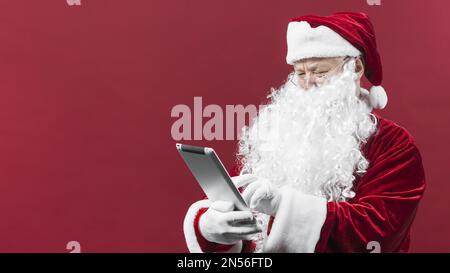 der weihnachtsmann hat ein Tablet benutzt. Auflösung und hochwertige Fotos Stockfoto