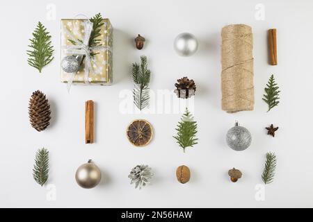 Geschenkbox in der Nähe von Nadelzweigen schnappt sich die Spulle dreht die Zierkugeln. Auflösung und hochwertige Fotos Stockfoto