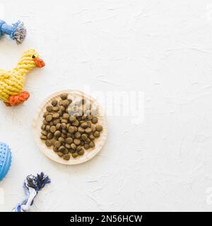 Teller mit Essen in der Nähe von Tierspielzeug. Auflösung und hochwertige Fotos Stockfoto