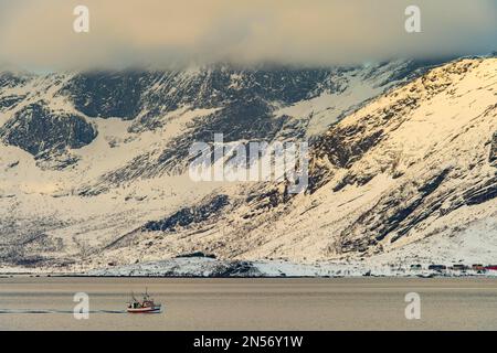 Fischerboot im Winter skandinavische Landschaft am Fjord, Meer, Berge, Schnee, Ramberg, Nordland, Lofoten, Norwegen Stockfoto