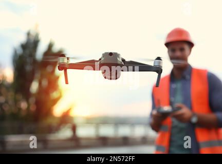 Bauarbeiter, die Drohne mit Fernsteuerung auf der Baustelle bedienen. Luftaufnahmen Stockfoto