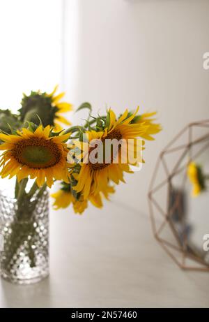 Vase mit schönen gelben Sonnenblumen auf dem Tisch Stockfoto
