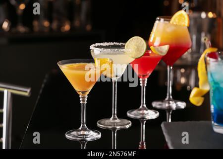 Verschiedene leckere Cocktails auf schwarzem Tisch in der Bar Stockfoto