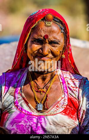 Farbenfroh gekleidete Wüstenbewohner, Schlammhütten in der Thar Wüste, Thar Wüste, Rajasthan, Indien Stockfoto