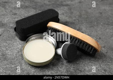 Komposition mit Schuhpflegezubehör auf grauem Hintergrund, Nahaufnahme Stockfoto
