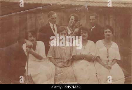 Vintage-Foto, das die Familie mit ihnen zeigt, die das Hündchen liebt / Vintage-Gedächtnis / gute alte Zeiten / Hündchen in der Hand halten / Hunde umarmen / Hund umarmen / Hund unter den Armen halten Stockfoto