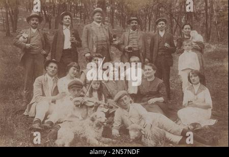 Vintage-Foto, das die Familie mit ihnen zeigt, die das Hündchen liebt / Vintage-Gedächtnis / gute alte Zeiten / Hündchen in der Hand halten / Hunde umarmen / Hund umarmen / Hund unter den Armen halten Stockfoto