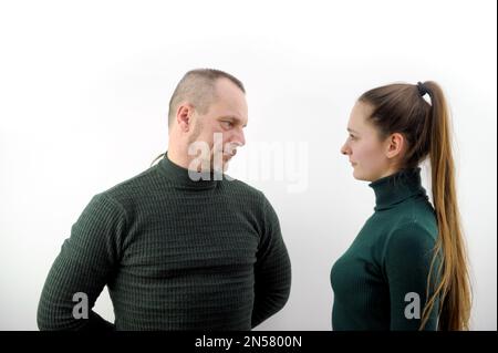 Foto eines attraktiven selbstbewussten Bruders, der grüne Pullover trägt, die Hände gekreuzt und sich ansieht, isolierter weißer Hintergrund Stockfoto