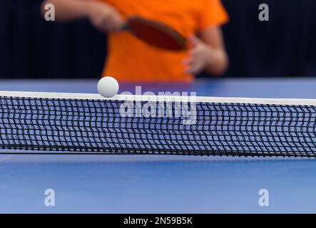 Der Junge spielt Tischtennis im Freien Stockfoto