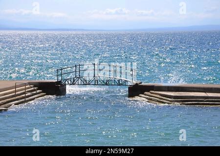 Kleine Fußgängerbrücke am Strand von Slatina in der Stadt Opatija.Kroatien, schöne Riviera von Opatija am Kvarner, beliebter Strand Slatina und Fußgängerbrücke in sc Stockfoto