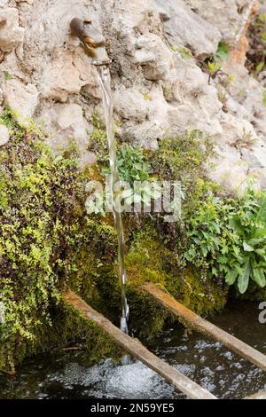 Süßwasserbrunnen über dem Bach im Garten der Abtei Gellone im berühmten Dorf Saint Guilhem le Desert, das von der UNESCO in Frankreich geschützt wird Stockfoto