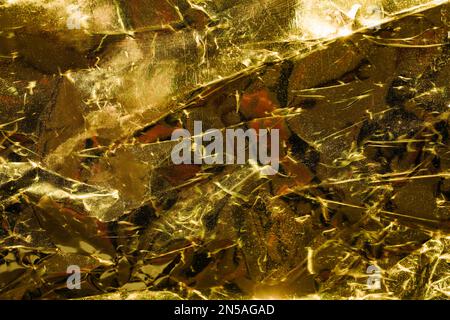 Zerkratzter und zerknitterter goldener Papierhintergrund. Grunge-Textur Stockfoto