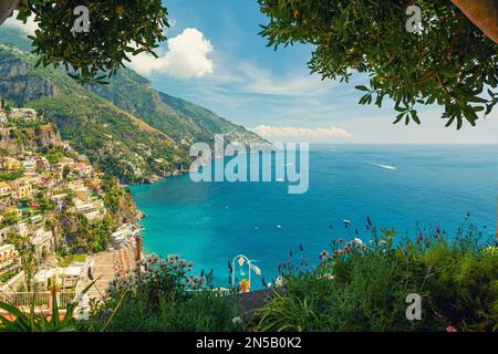 Blick auf die italienische Küstenstadt Positano an der Amalfiküste von der Terrasse mit Blumen und Bäumen, Kampanien, Italien. Beliebtes Resort oder Reiseziel Stockfoto