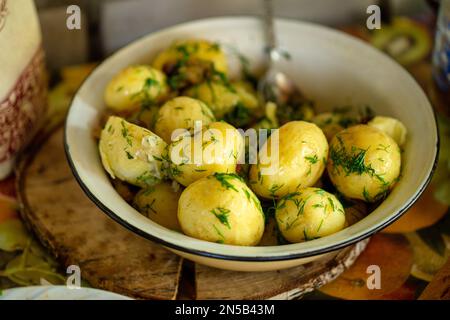 Frisch gekochte Frühkartoffeln mit frischem Dill auf rustikalem Hintergrund Stockfoto
