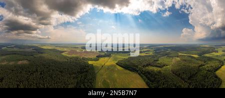 Sonnige Landschaft mit Sonnenstrahlen Sommerlandschaft Panorama aus der Vogelperspektive. Blick von oben auf Wald, Weiden, Felder und Fluss Stockfoto