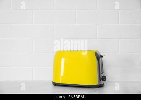 Moderner gelber Toaster auf der Arbeitsfläche in der Küche. Platz für Text Stockfoto