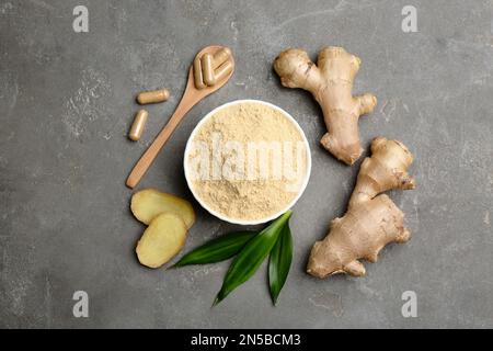 Flache Laienzusammensetzung mit frischem und trockenem Ingwer auf grauem Tisch Stockfoto