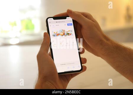 MYKOLAIV, UKRAINE - 27. OKTOBER 2020: Mann, der die Google-Suchmaschine auf einem Smartphone vor unscharfem Hintergrund verwendet, Nahaufnahme Stockfoto