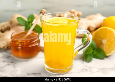 Immunitätsfördernde Getränke und Zutaten auf weißem Marmortisch, Nahaufnahme Stockfoto