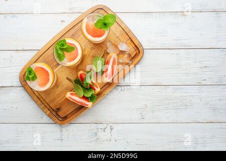 Sommerliche erfrischende Fruchtgetränke mit Eis auf grauem Hintergrund. Flach liegend, Draufsicht Stockfoto