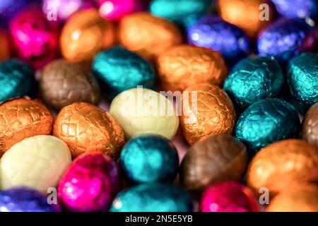 Großer Haufen bunter Schokoladeneier, glänzendes Osterkonzept, Happy easter Nahaufnahme Süßigkeiten Konzept Makro Stockfoto